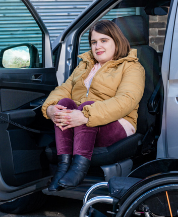 A woman use a lift adaptation to leave her Motability Scheme vehicle