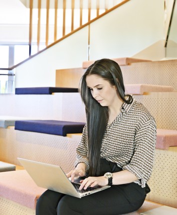 A woman works on a laptop in an office