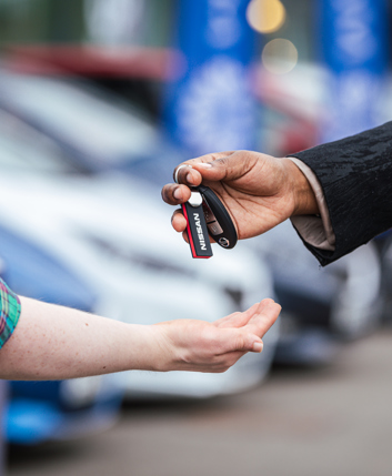 A car dealer handing car keys to a new Motability Scheme customer