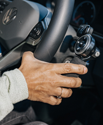 Close-up of a woman's hand using a steering wheel adaptation