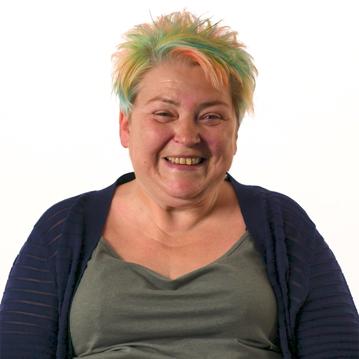 A woman with short, colourful hair smiling